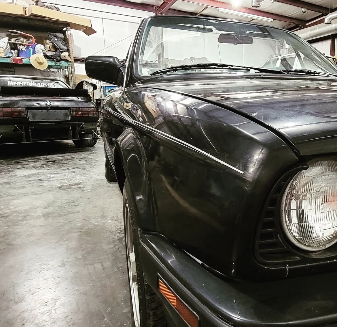Classic square body car in black sitting in the auto art restoration body shop