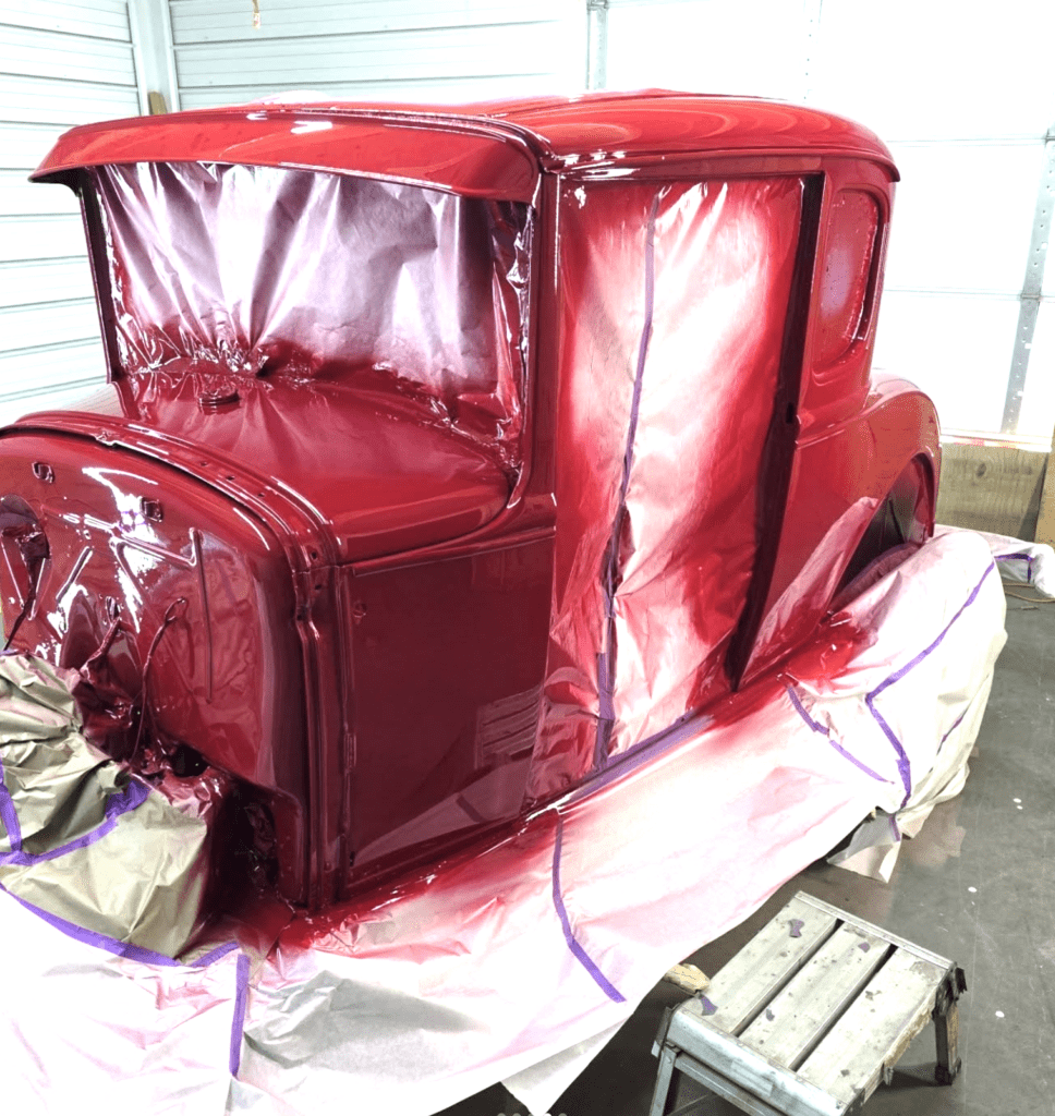 Freshly painted red vintage car with wrap still on