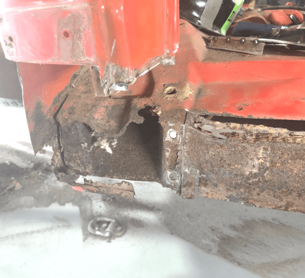 Rusted area on an old orange car